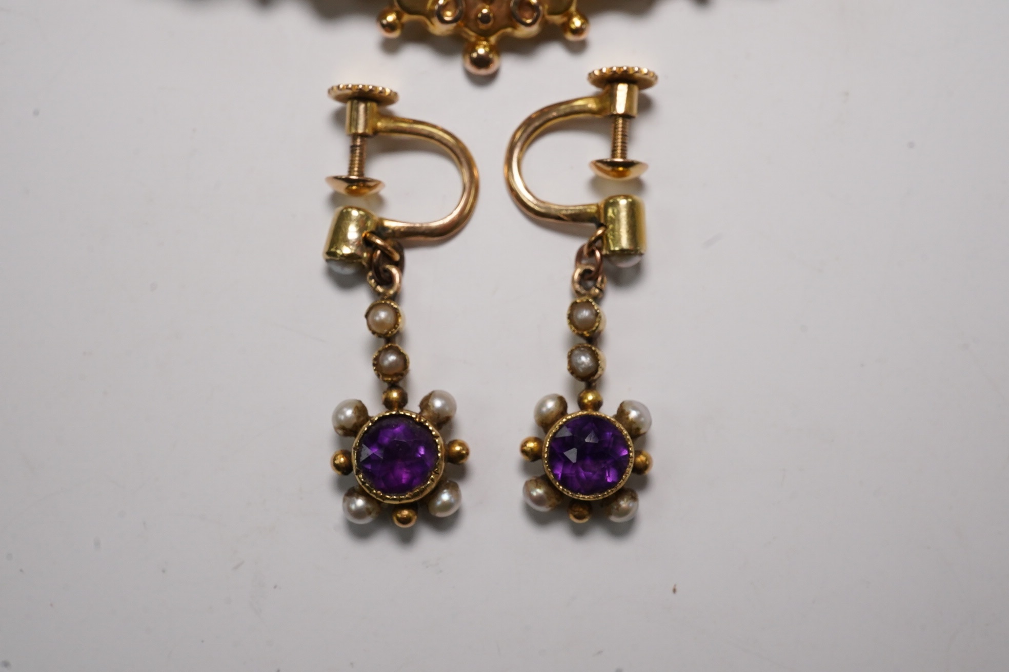 A pair of antique yellow metal, amethysts and seed pearl set drop earrings, 22mm and a Victorian 9ct, ruby and split pearl set brooch, gross weight 6.6 grams. Condition - fair to good